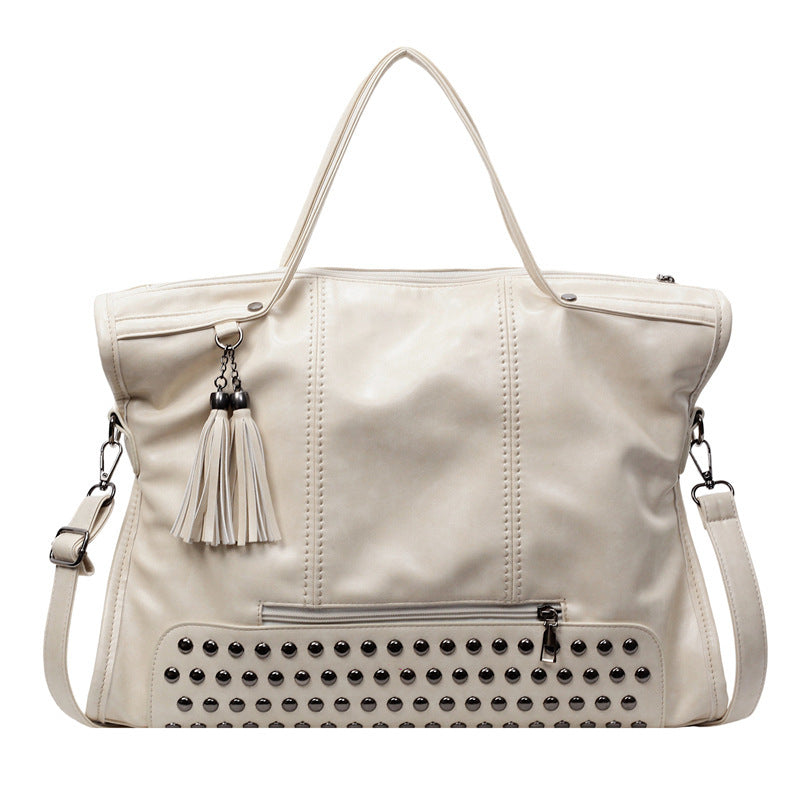 Beige handbag with studded detail and tassel