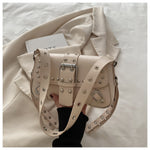 Beige handbag with studded details held