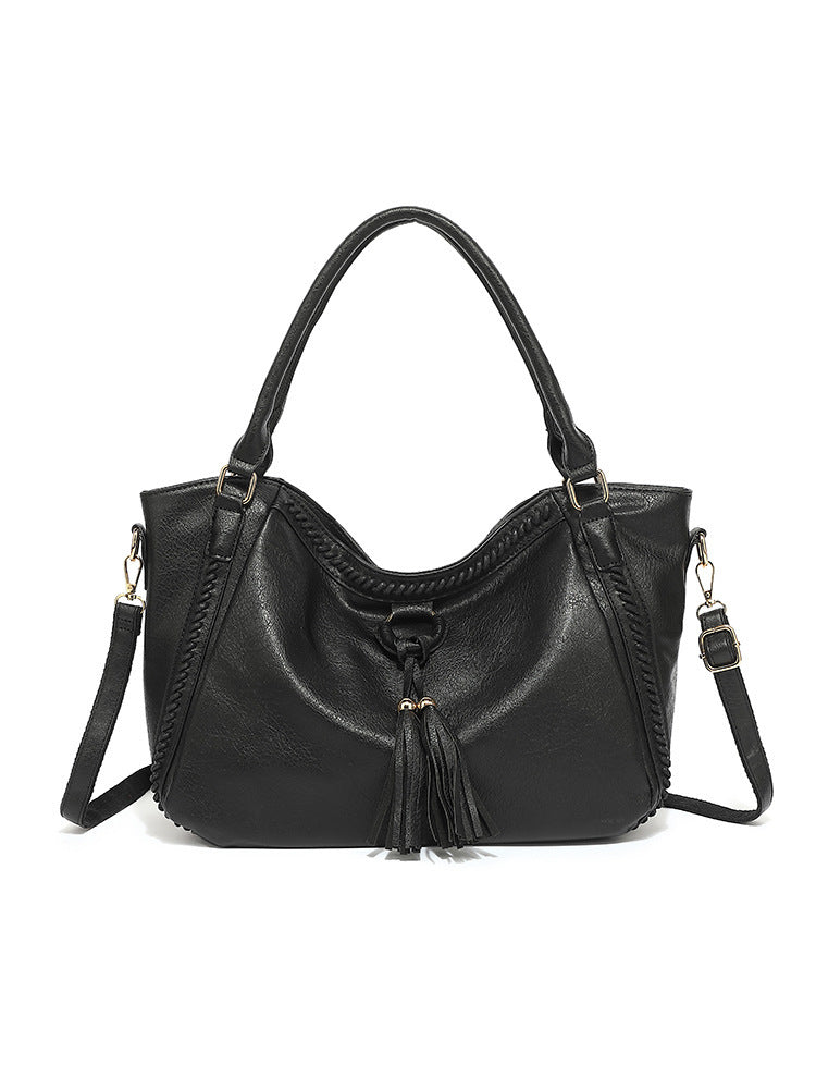 Black handbag with a strap on a white background