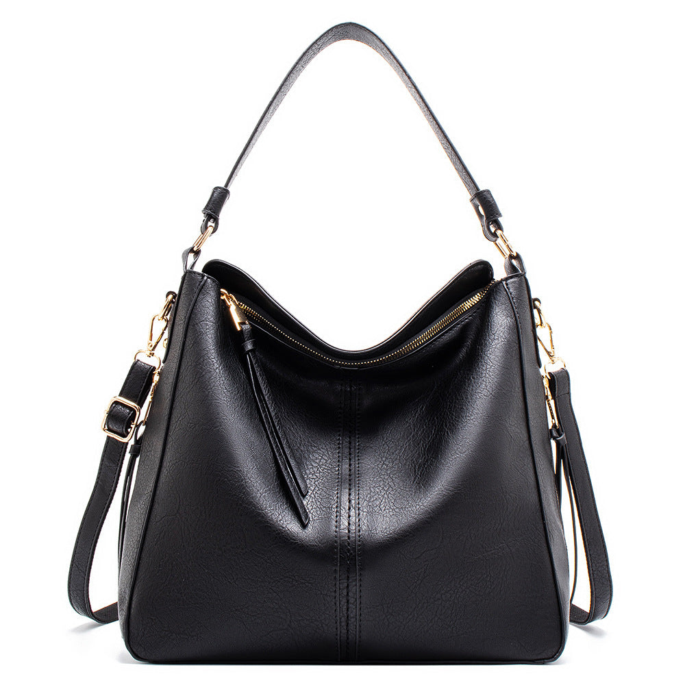 Black handbag with gold accents on a white background