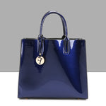 Blue glossy handbag with a gold tag on a gray background