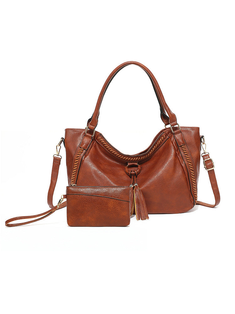 Brown leather handbag with a shoulder strap on a white background
