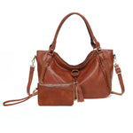 Brown leather handbag with a shoulder strap on a white background