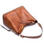 Brown leather handbag with a shoulder strap on a white background