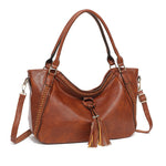 Brown leather handbag with tassel on a white background