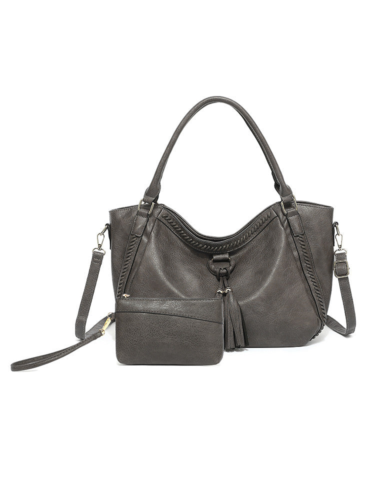 Gray handbag with a shoulder strap on a white background
