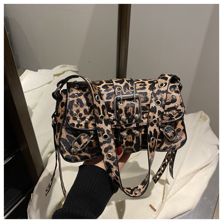 Leopard print handbag held by a person against a neutral background