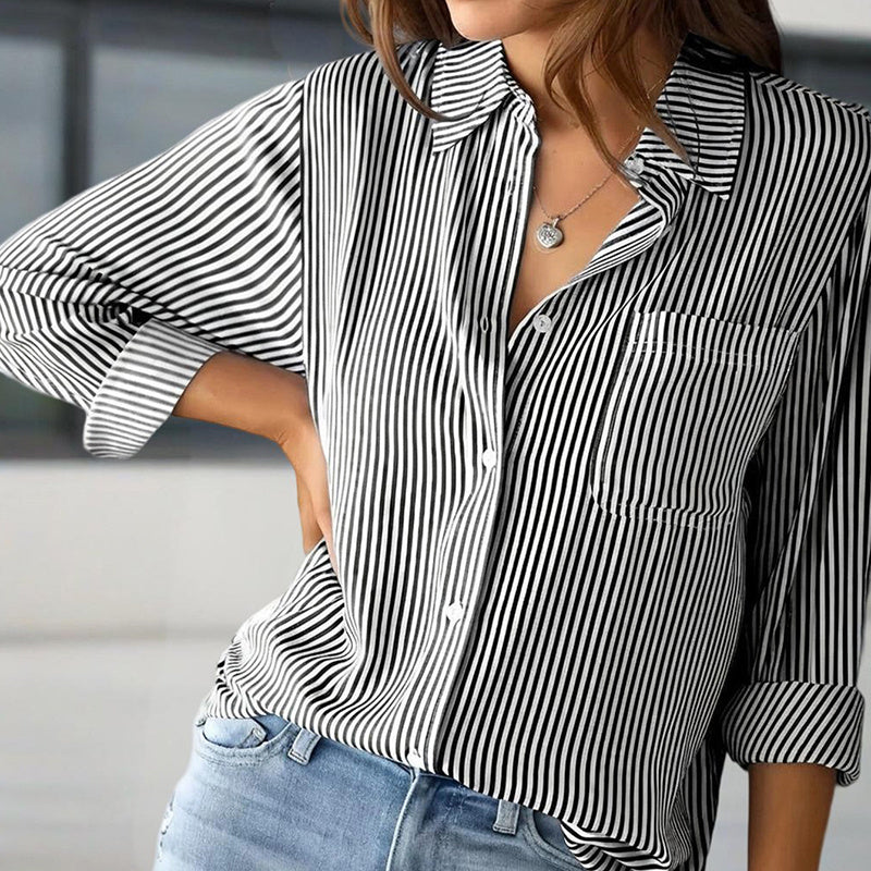 Person wearing a black and white striped shirt with rolled-up sleeves and blue jeans.