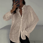 Person wearing a sparkly beige cardigan against a neutral background