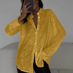 Person wearing a yellow sequin shirt against a neutral background