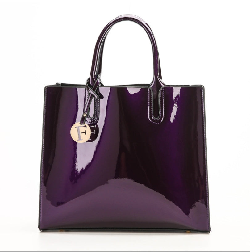 Purple handbag with a gold tag on a white background