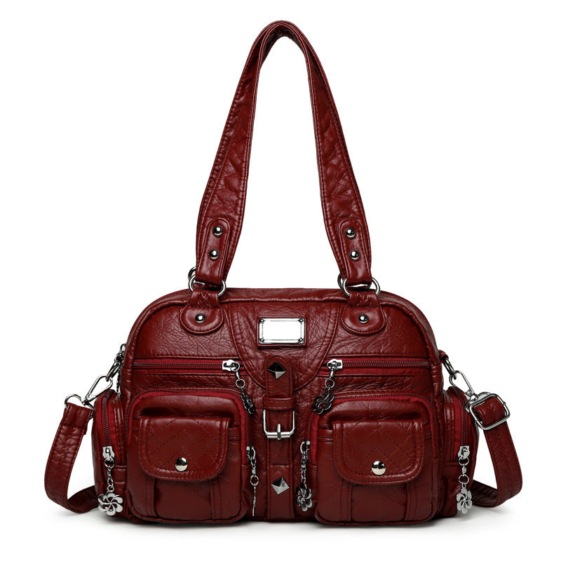 Red handbag with multiple pockets and straps on a white background