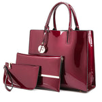 Red patent leather handbag and matching pouch on a white background
