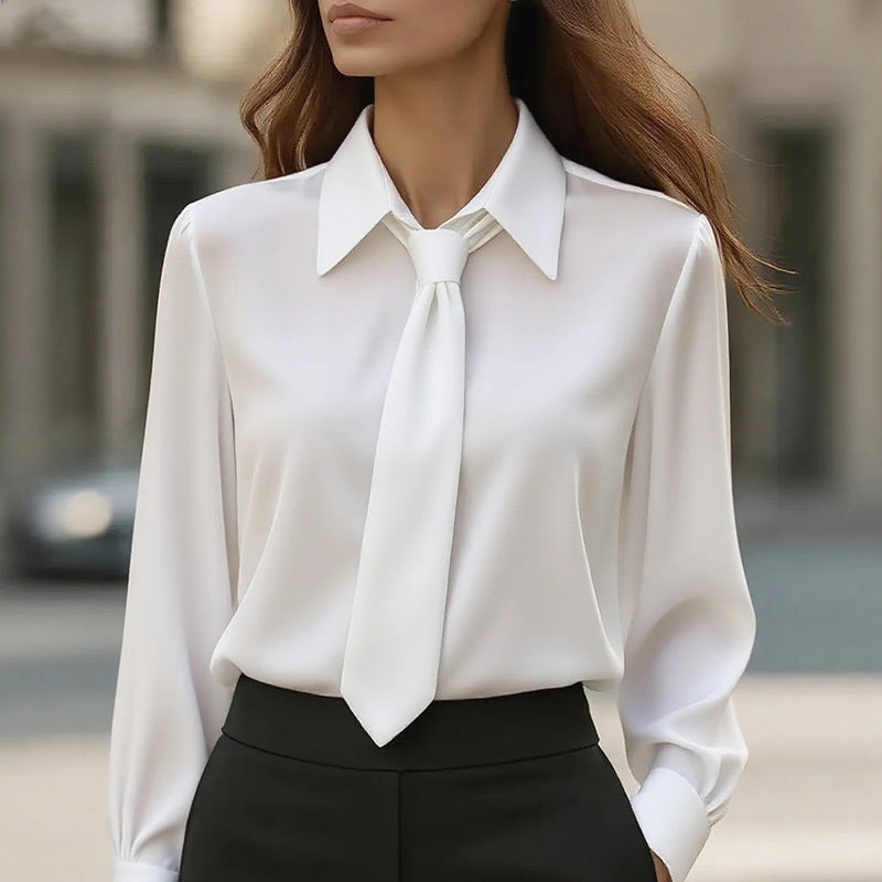 White blouse with a tie detail worn by a person outdoors.