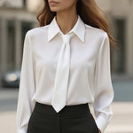 White blouse with a tie detail worn by a person outdoors.