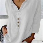White long-sleeve shirt with buttons worn by a person against 