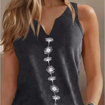 Woman wearing a black sleeveless top with white floral patterns on a neutral background