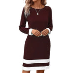 Woman wearing a burgundy dress with white trim in an urban setting