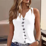 Woman wearing a white sleeveless top with black floral patterns.